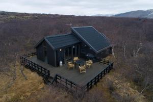 une vue aérienne sur une cabine noire avec une terrasse dans l'établissement Very cozy cottage, Rauðará, with sauna, à Gilsbakki