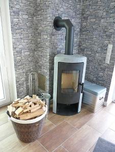 un camino in una stanza con un cesto di legna di Ferienbungalow Fehmarnblick a Presen