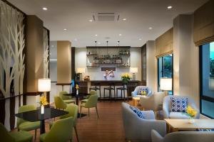 a lobby with a bar and tables and chairs at Amari Vang Vieng in Vang Vieng