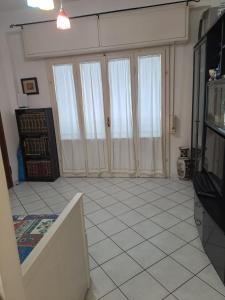 皮昂比诺Appartamento STELLA MARINA的客厅设有三扇大型推拉门，地面铺有瓷砖。