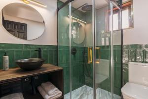 a bathroom with green tiled walls and a glass shower at Casa Lavanda in Granada