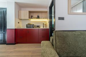 a kitchen with red cabinets and a couch in a room at Casa Lavanda in Granada