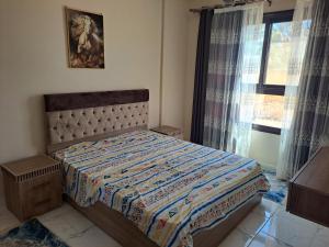 a bedroom with a bed and a window with curtains at Turtles beach resorts in Hurghada