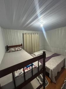a bedroom with two bunk beds in a house at Casa Aconchegante em Biguaçu próximo às praias in Biguaçu