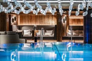 a swimming pool in a hotel room with a couch at Tradition Julen Hotel in Zermatt