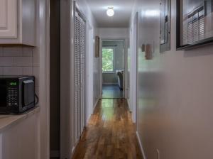 a hallway leading to a kitchen with a microwave at 3BR Comfort Hub Newark 15 mins NYC in Jersey City
