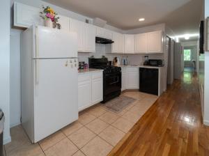 a kitchen with white cabinets and a white refrigerator at 3BR Comfort Hub Newark 15 mins NYC in Jersey City