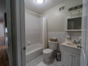 a white bathroom with a toilet and a sink at 3BR Comfort Hub Newark 15 mins NYC in Jersey City
