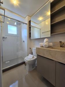 une salle de bain avec toilettes, douche et lavabo dans l'établissement Apartamento Reserva das Orquídeas, à Gramado 5 autres photos
