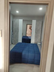 a bedroom with a blue bed and a mirror at Al civico 14 in Foggia +2 photos