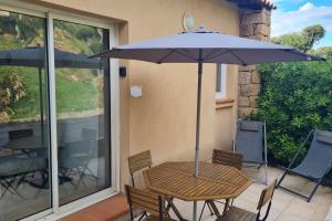 塞拉迪费罗Appartement climatisé dans une résidence avec piscine mer à pied的庭院内桌椅和遮阳伞