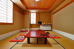 a room with a table and two mats on the floor at Resort Inn Chitose in Nozawa Onsen
