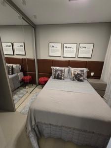 - une chambre avec un lit dans une pièce avec un miroir dans l'établissement Apartamento Reserva das Orquídeas, à Gramado