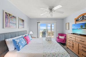 a bedroom with a bed and a flat screen tv at Oceanfront 3BR with Stunning Views, Private Balcony and Pool in Myrtle Beach