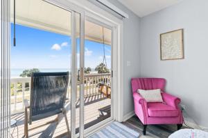 a pink chair on a balcony with a view of the ocean at Oceanfront 3BR with Stunning Views, Private Balcony and Pool in Myrtle Beach