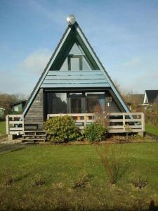 une maison avec un toit mansardé avec une fenêtre dans l'établissement Tossi Haus 107 In Fedderwardersiel, à Butjadingen