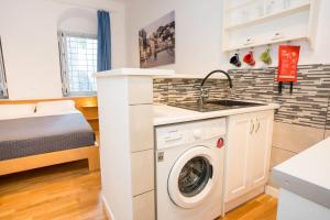a small kitchen with a washing machine and a bed at Hydra's Ruby in Hydra