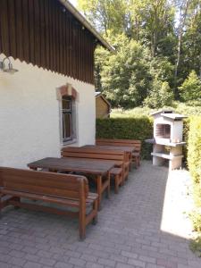 a row of wooden benches sitting outside of a building at Wolfsgrund in Sayda