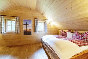 a bedroom with a bed and two windows at Wirths Hütte in Innerkrems +7 photos