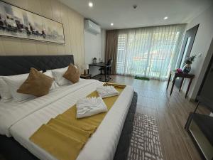 un grande letto con due cuscini sopra in una stanza di The Bay cliff By Tris a Patong Beach