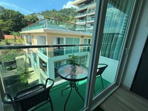 un balcone con tavolo e sedie su un balcone di The Bay cliff By Tris a Patong Beach