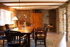 ein Esszimmer mit einem Holztisch und Stühlen in der Unterkunft Ferienhaus In Walscheid Mit Terrasse, Grill in Walscheid