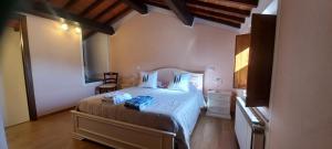 a bedroom with a bed and a chair in it at La Corte Antica in Pienza