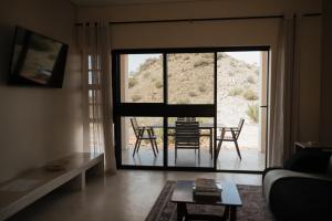 a living room with a view of a table and chairs at Bergendam Eco Lodge in Venterstad