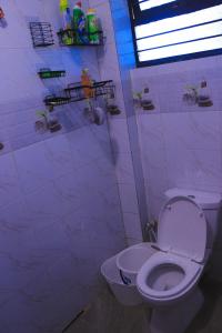 un bagno bianco con wc e doccia di Empiris Luxe Homes a Narok