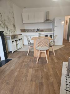a kitchen with a wooden table and chairs at Appartement coquet à la Machine in La Machine +2 photos