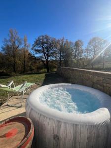 a hot tub in a large tire next to a chair at Bachvarov house Бъчваровата къща in Palitsi +11 photos