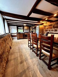 une salle à manger avec des chaises en bois et une cuisine dans l'établissement Bachvarov house Бъчваровата къща, à Palitsi