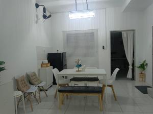 a dining room with a white table and chairs at BB Homestay in Tuaran