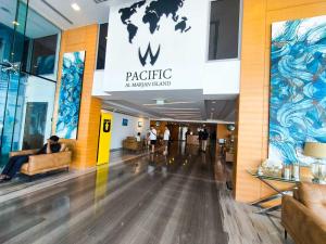 a lobby of a shopping mall with a person sitting in a chair at Azure Sands 2BR Escape with Priavte Beach and Pool in Al Marjan Island in Ras al Khaimah +37 photos