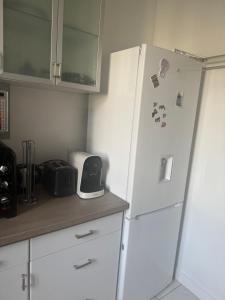 a kitchen with a refrigerator with magnets on it at Cute appartement in Boulogne-Billancourt