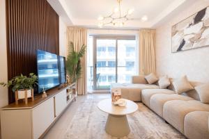 a living room with a couch and a tv at Azure Sands 2BR Escape with Priavte Beach and Pool in Al Marjan Island in Ras al Khaimah