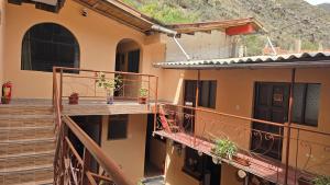 a building with a balcony with stairs and a door at Refugio Sagrado Boutique in Ollantaytambo