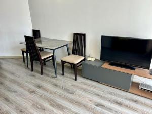 ein Esszimmer mit einem Tisch und einem Flachbildfernseher in der Unterkunft Atlantis Resort & 4 swimming pools & Spa & Апартамент in Burgas City