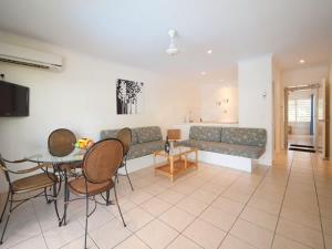 un salon avec un canapé, une table et des chaises dans l'établissement Coral Mango, à Airlie Beach