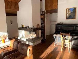 Una sala de estar con un sofá y una chimenea. en Casa Caglina, en Disentis