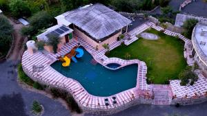 eine Luftaufnahme eines Hauses mit Swimmingpool in der Unterkunft Jawai Palash Resort by Alivaa in Bīsalpur