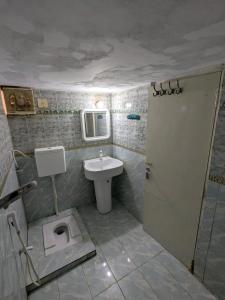 a bathroom with a sink and a toilet at Family Inn Guest House in Karachi