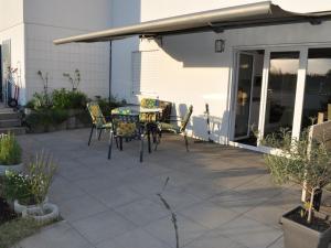 a patio with a table and chairs on it at Wohnung Mit Großer Gartenterrasse Und Ausblick in Argenbühl