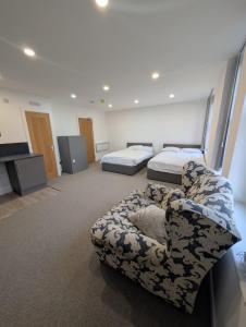 a room with two beds and a couch in it at OYO Park Lodge Preston in Preston