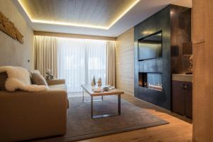a living room with a couch and a fireplace at Hôtel de Rougemont & Spa in Gstaad