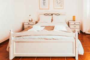 a bedroom with a white bed and two night stands at Altura Beach Villa by GT House in Altura