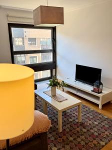 a living room with a tv and a table at Primera Linea de Playa in Bueu