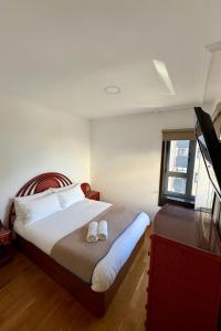 a bedroom with a bed with two shoes on it at Primera Linea de Playa in Bueu