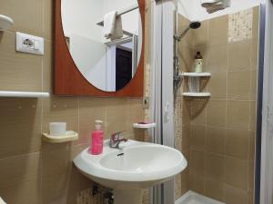 une salle de bain avec un lavabo et un miroir dans l'établissement App - Il Fenicottero con parcheggio gratuito ad Orbetello, à Orbetello 34 autres photos