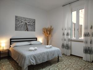 une chambre avec un lit avec deux serviettes dessus dans l'établissement App - Il Fenicottero con parcheggio gratuito ad Orbetello, à Orbetello